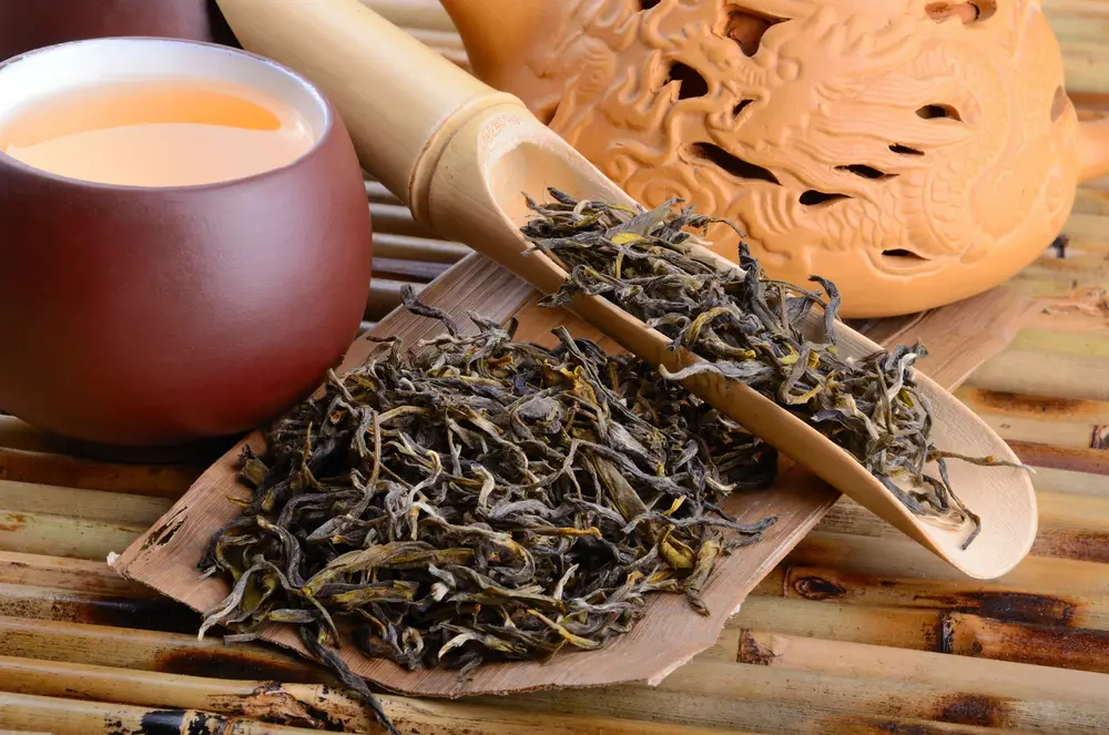 oolong tea in cup with dry leaves