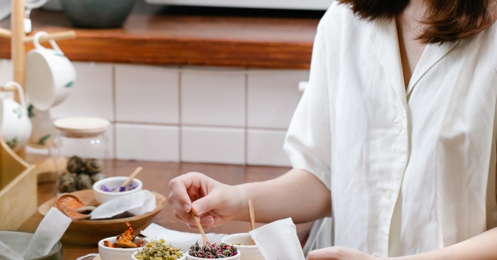 woman putting ingredients in tea bag