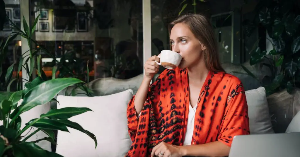 a woman drinking a cup hot chai tea