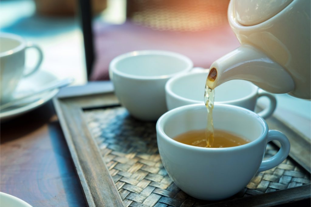 white tea being poured in a tea pot